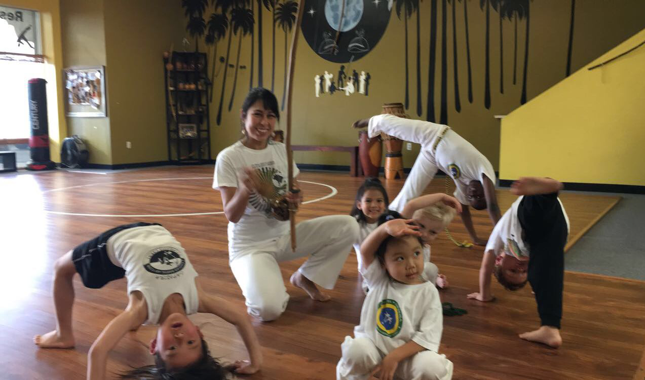 Kids pose in capoeira class.